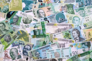 Çeşitli para birimleri para banknotları yeşil renkli. Farklı ülkelerden gelen birçok nakit para yığını yakın mesafede. Dünya ekonomisi ve döviz kuru kavramı