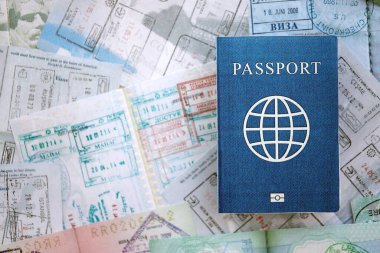 Seyahat ve sınır geçişinden sonra içi renkli pullarla dolu bir pasaport. Turizm ve sınır denetimi kavramı. Göçmenlik ve dünya çapında seyahat