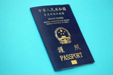 Hong Kong Special Administrative Region HKSAR Passport lies on blue table background close up. Hong Kong blue new passport book in details
