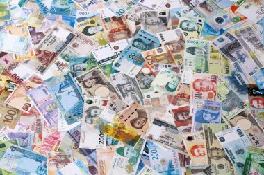 Dünyanın çeşitli para birimlerinden farklı renkte banknotlar. Masada yığınla para var. Yakın plan.