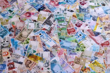 Dünyanın çeşitli para birimlerinden farklı renkte banknotlar. Para değişimi konsepti. Masada yığınla para var. Yakın plan.