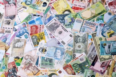 Dünyanın çeşitli para birimlerinden farklı renkte banknotlar. Masada yığınla para var. Yakın plan.