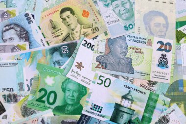 Çeşitli para birimleri para banknotları yeşil renkli. Farklı ülkelerden gelen birçok nakit para yığını yakın mesafede. Dünya ekonomisi ve döviz kuru kavramı