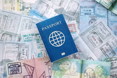 Seyahat ve sınır geçişinden sonra içi renkli pullarla dolu bir pasaport. Turizm ve sınır denetimi kavramı. Göçmenlik ve dünya çapında seyahat