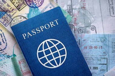 Seyahat ve sınır geçişinden sonra içi renkli pullarla dolu bir pasaport. Turizm ve sınır denetimi kavramı. Göçmenlik ve dünya çapında seyahat