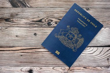 Şili Cumhuriyeti pasaportu ahşap masaya yakın duruyor. Şili mavisi yeni pasaport defteri detaylarıyla