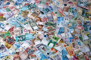 Dünyanın çeşitli para birimlerinden farklı renkte banknotlar. Para değişimi konsepti. Masada yığınla para var. Yakın plan.