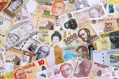 Çeşitli para birimleri para banknotları sarı ve turuncu renklerde. Farklı ülkelerden gelen birçok nakit para yığını yakın mesafede. Dünya ekonomisi ve döviz kuru kavramı