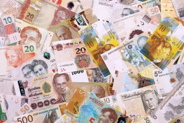 Çeşitli para birimleri para banknotları sarı ve turuncu renklerde. Farklı ülkelerden gelen birçok nakit para yığını yakın mesafede. Dünya ekonomisi ve döviz kuru kavramı