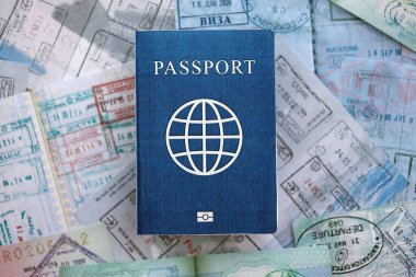 Seyahat ve sınır geçişinden sonra içi renkli pullarla dolu bir pasaport. Turizm ve sınır denetimi kavramı. Göçmenlik ve dünya çapında seyahat