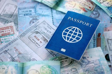 Seyahat ve sınır geçişinden sonra içi renkli pullarla dolu bir pasaport. Turizm ve sınır denetimi kavramı. Göçmenlik ve dünya çapında seyahat