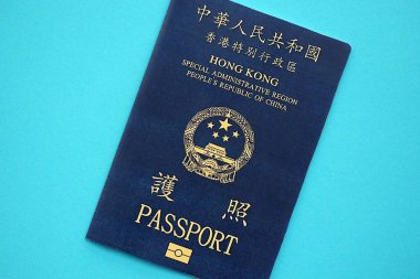 Hong Kong Özel İdari Bölgesi HKSAR pasaportu mavi masa arkasında, yakın planda. Hong Kong mavi pasaport defteri.
