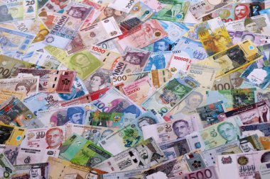 Dünyanın çeşitli para birimlerinden farklı renkte banknotlar. Masada yığınla para var. Yakın plan.