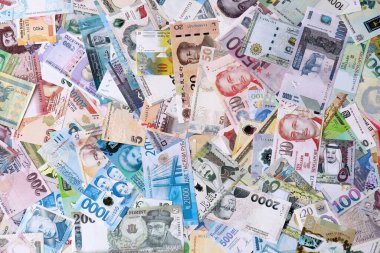 Dünyanın çeşitli para birimlerinden farklı renkte banknotlar. Para değişimi konsepti. Masada yığınla para var. Yakın plan.