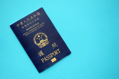 Hong Kong Özel İdari Bölgesi HKSAR pasaportu mavi masa arkasında, yakın planda. Hong Kong mavi pasaport defteri.