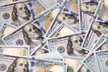 Yüzlerce dolarlık banknotlar düz bir yüzeyde karmaşık tasarımlar sergiliyor. 100 dolarlık banknotta Franklin 'in para geçmişi