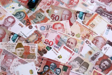 Çeşitli para birimleri para banknotları kırmızı renkli. Farklı ülkelerden gelen birçok nakit para yığını yakın mesafede. Dünya ekonomisi ve döviz kuru kavramı