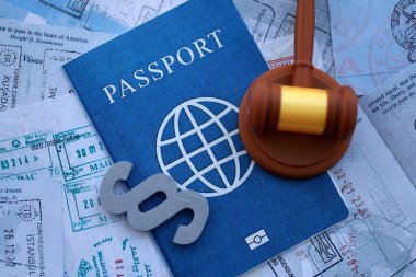 Paragraf sembolü ve çekiç, seyahat ve turizmden sonra renkli pullarla dolu pasaport sayfalarına göre yargılanıyor. Sınır kontrolü ve dava konsepti. Göçmenlik ve dünya çapında seyahat
