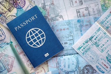 Seyahat ve sınır geçişinden sonra içi renkli pullarla dolu bir pasaport. Turizm ve sınır denetimi kavramı. Göçmenlik ve dünya çapında seyahat