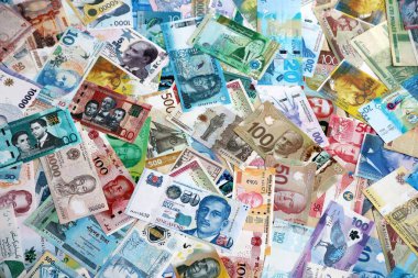 Dünyanın çeşitli para birimlerinden farklı renkte banknotlar. Masada yığınla para var. Yakın plan.