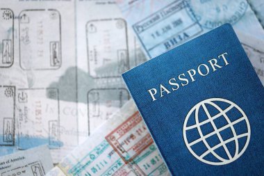 Seyahat ve sınır geçişinden sonra içi renkli pullarla dolu bir pasaport. Turizm ve sınır denetimi kavramı. Göçmenlik ve dünya çapında seyahat