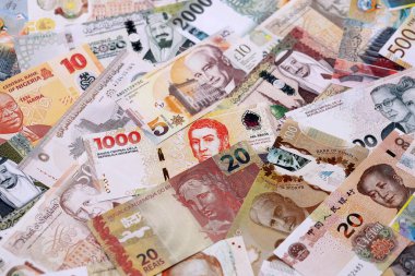 Çeşitli para birimleri para banknotları sarı ve turuncu renklerde. Farklı ülkelerden gelen birçok nakit para yığını yakın mesafede. Dünya ekonomisi ve döviz kuru kavramı