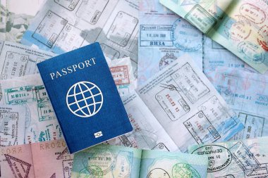 Seyahat ve sınır geçişinden sonra içi renkli pullarla dolu bir pasaport. Turizm ve sınır denetimi kavramı. Göçmenlik ve dünya çapında seyahat