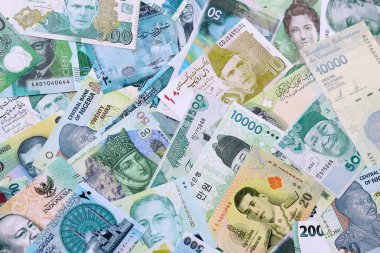 Çeşitli para birimleri para banknotları yeşil renkli. Farklı ülkelerden gelen birçok nakit para yığını yakın mesafede. Dünya ekonomisi ve döviz kuru kavramı