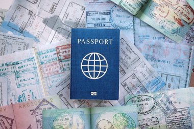 Seyahat ve sınır geçişinden sonra içi renkli pullarla dolu bir pasaport. Turizm ve sınır denetimi kavramı. Göçmenlik ve dünya çapında seyahat