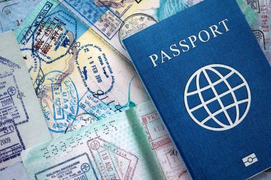 Seyahat ve sınır geçişinden sonra içi renkli pullarla dolu bir pasaport. Turizm ve sınır denetimi kavramı. Göçmenlik ve dünya çapında seyahat