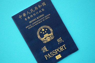 Hong Kong Special Administrative Region HKSAR Passport lies on blue table background close up. Hong Kong blue new passport book in details