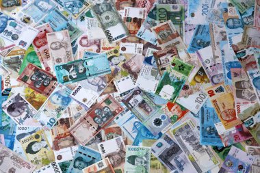 Dünyanın çeşitli para birimlerinden farklı renkte banknotlar. Masada yığınla para var. Yakın plan.