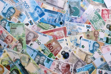 Dünyanın çeşitli para birimlerinden farklı renkte banknotlar. Para değişimi konsepti. Masada yığınla para var. Yakın plan.