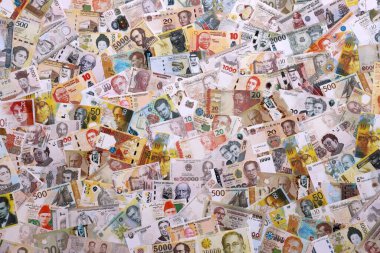 Çeşitli para birimleri para banknotları sarı ve turuncu renklerde. Farklı ülkelerden gelen birçok nakit para yığını yakın mesafede. Dünya ekonomisi ve döviz kuru kavramı