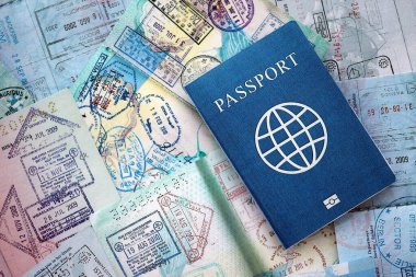 Seyahat ve sınır geçişinden sonra içi renkli pullarla dolu bir pasaport. Turizm ve sınır denetimi kavramı. Göçmenlik ve dünya çapında seyahat