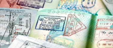 Seyahat ve sınır geçişinden sonra renkli pullarla dolu büyük bir pasaport sayfası. Turizm ve sınır denetimi kavramı. Göçmenlik ve dünya çapında seyahat