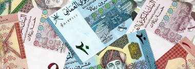 Umman riyal kâğıdı banknotları masanın üzerine yığılmış. Umman OMR para birimi faturaları büyük miktarda. Umman 'da ekonomi, vergi ve bankacılık kavramı