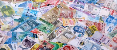 Dünyanın çeşitli para birimlerinden farklı renkte banknotlar. Para değişimi konsepti. Masada yığınla para var. Yakın plan.