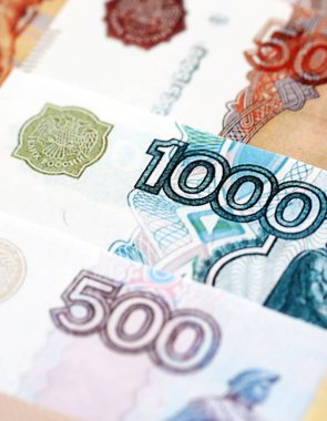 Rus rublesi banknotları masanın üstüne yığılmış. Rusya para birimi faturalarını büyük miktarda kesiyor. Rusya 'da ekonomi, vergilendirme ve bankacılık kavramı