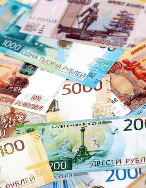 Rus rublesi banknotları masanın üstüne yığılmış. Rusya para birimi faturalarını büyük miktarda kesiyor. Rusya 'da ekonomi, vergilendirme ve bankacılık kavramı