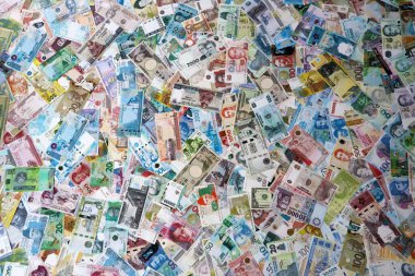 Dünyanın çeşitli para birimlerinden farklı renkte banknotlar. Masada yığınla para var. Yakın plan.