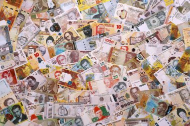 Çeşitli para birimleri para banknotları sarı ve turuncu renklerde. Farklı ülkelerden gelen birçok nakit para yığını yakın mesafede. Dünya ekonomisi ve döviz kuru kavramı