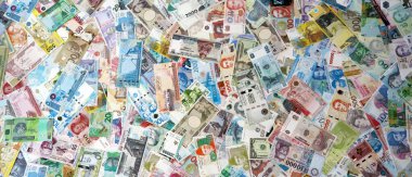 Dünyanın çeşitli para birimlerinden farklı renkte banknotlar. Masada yığınla para var. Yakın plan.