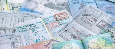 Seyahat ve sınır geçişinden sonra renkli pullarla dolu büyük bir pasaport sayfası. Turizm ve sınır denetimi kavramı. Göçmenlik ve dünya çapında seyahat