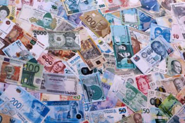 Dünyanın çeşitli para birimlerinden farklı renkte banknotlar. Masada yığınla para var. Yakın plan.