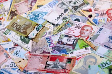 Dünyanın çeşitli para birimlerinden farklı renkte banknotlar. Masada yığınla para var. Yakın plan.