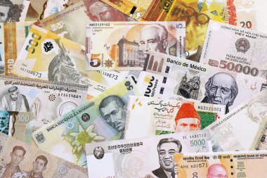 Çeşitli para birimleri para banknotları sarı ve turuncu renklerde. Farklı ülkelerden gelen birçok nakit para yığını yakın mesafede. Dünya ekonomisi ve döviz kuru kavramı