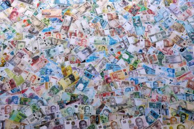 Farklı para birimlerinden bir sürü banknot. Rastgele para akışının arka planı kapanıyor. Döviz Borsası kavramı