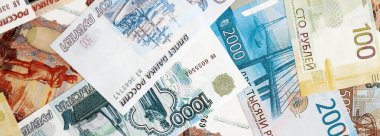 Rus rublesi banknotları masanın üstüne yığılmış. Rusya para birimi faturalarını büyük miktarda kesiyor. Rusya 'da ekonomi, vergilendirme ve bankacılık kavramı