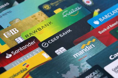 KYIV, UKRAINE - 28 Ocak 2026 Dünyanın çeşitli bankalarının logoları olan büyük bir kredi kartı yığını. Kredi kartı kullanımı kavramı veya banka kartı kullanımı. Bankacılık, ekommerce ve dijital fon transferi